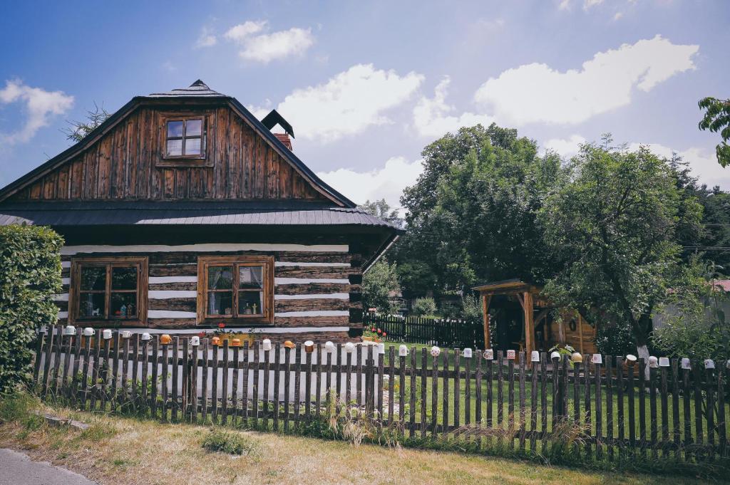 a wooden house with a fence in front of it at Pod Buchtou in Daňkovice