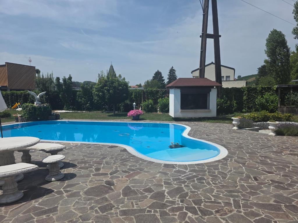 a swimming pool with a windmill in the background at Ferienwohnungen Forever in Gamlitz