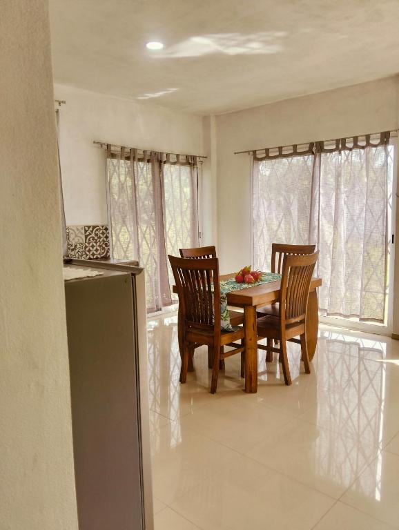a dining room with a wooden table and chairs at Casa Imox in Bacalar