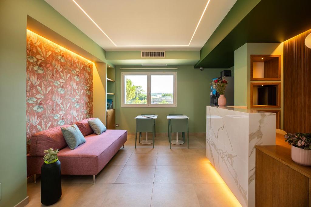 a living room with a pink couch and a window at Salvia Hotel in Poggio Moiano
