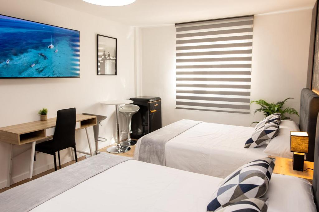 a bedroom with two beds and a desk and a table at Viceda Home in Yecla