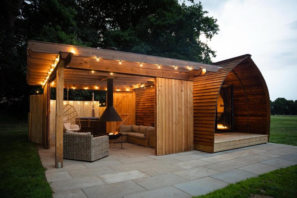 a wooden pergola with lights on a patio at Bainton Burrows by Wigwam Holidays in Great Driffield