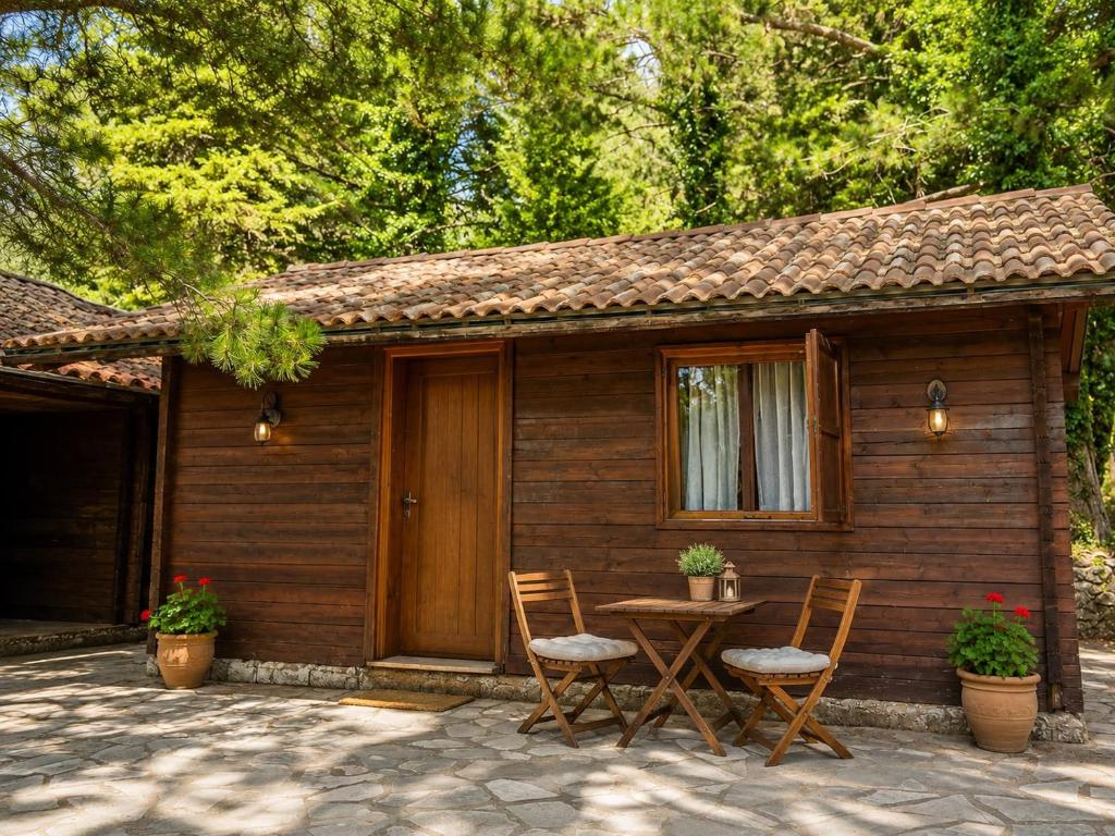 a table and chairs in front of a cabin at Llogara Wood Lodge in Vlorë