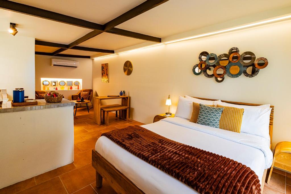 a bedroom with a large bed and a kitchen at Esensia Boutique Studio in Oranjestad