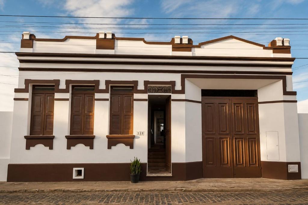 a white building with brown doors and windows at Casaboa Casarão Boutique Orla in Itacaré