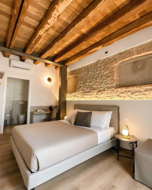 a bedroom with a large bed and a brick wall at Agriturismo Al Capretto in San Vendemiano