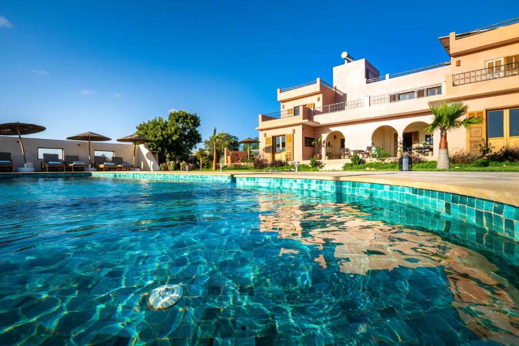 a swimming pool in front of a house at Villa de luxe Sakina in Essaouira