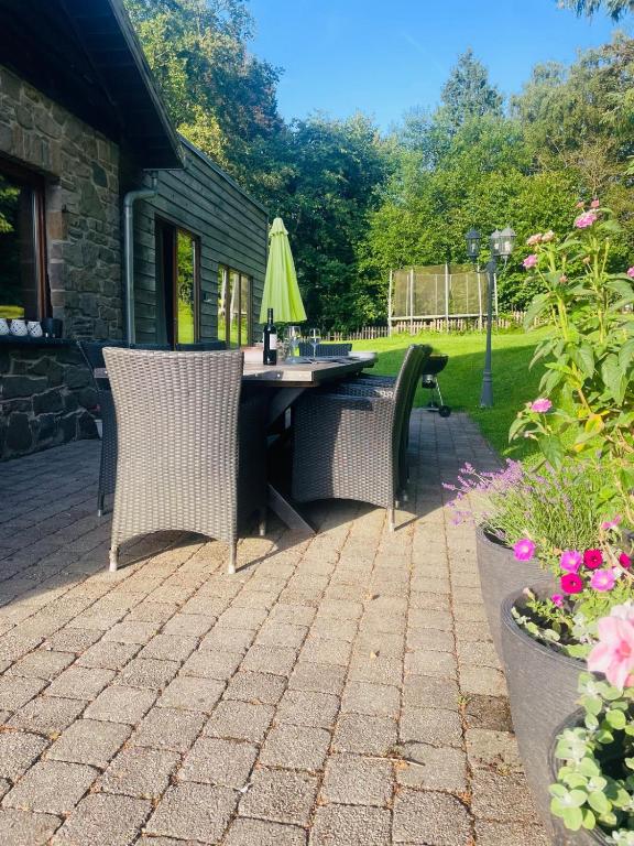 a patio with two chairs and a table with an umbrella at Les Grosses Pierres à Spa in Spa