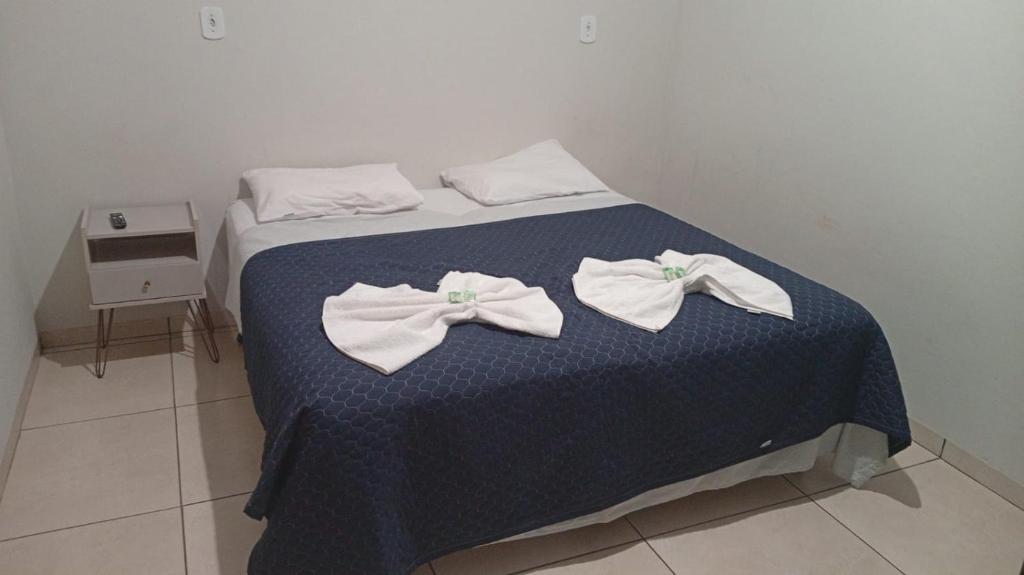 a bed with white bows on top of it at Hotel AD Cassilândia in Cassilândia