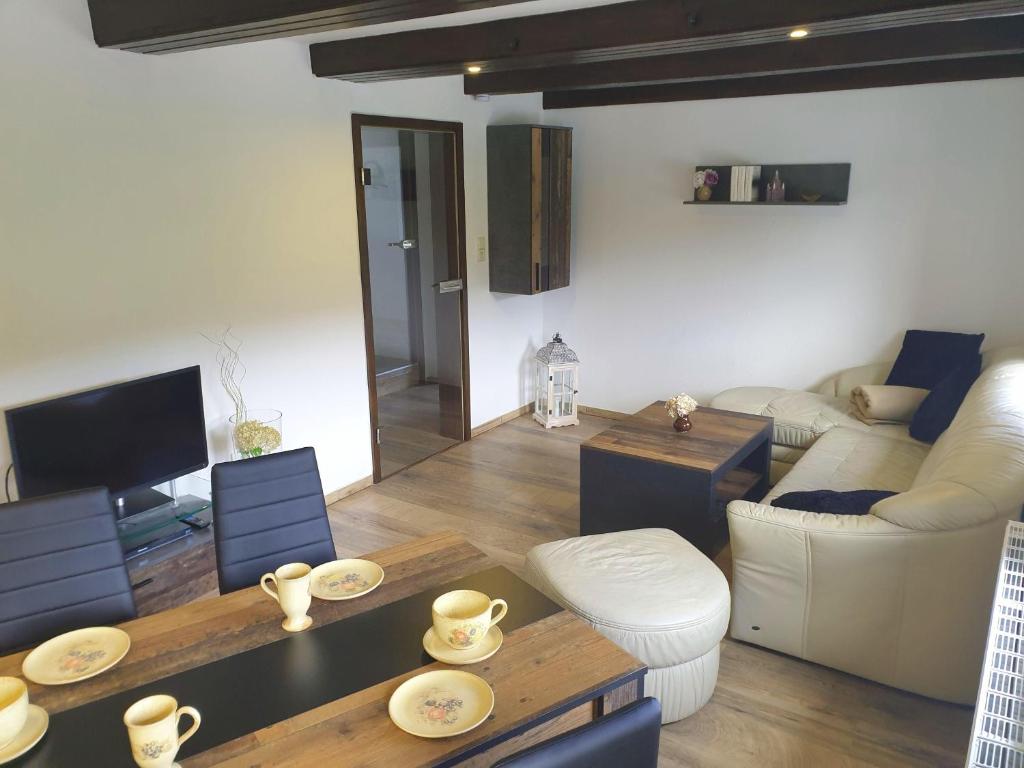 a living room with a couch and a table at Elbblick-kleine-Wohnung-mit-Terrasse in Gollhofen