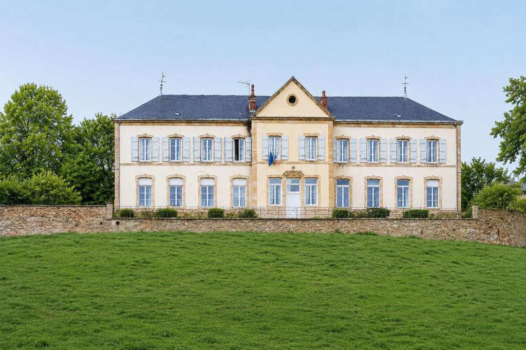 a large white house with a large grass field at Maison Lanty in Lanty