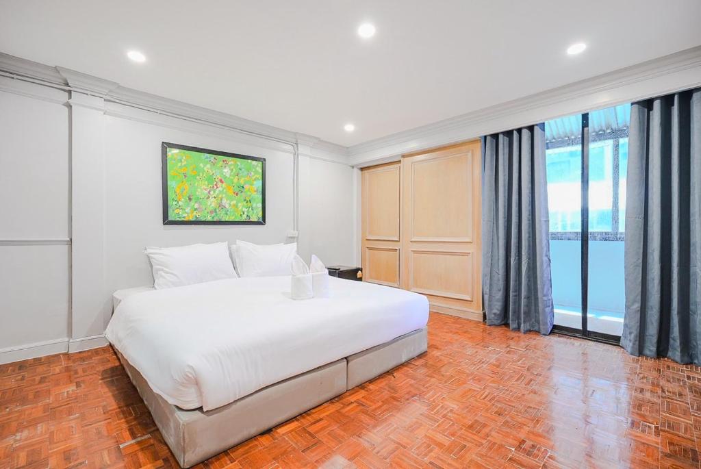 a bedroom with a white bed and a large window at CASA Sukhumvit 39 - สุขุมวิท 39 in Klong Toi