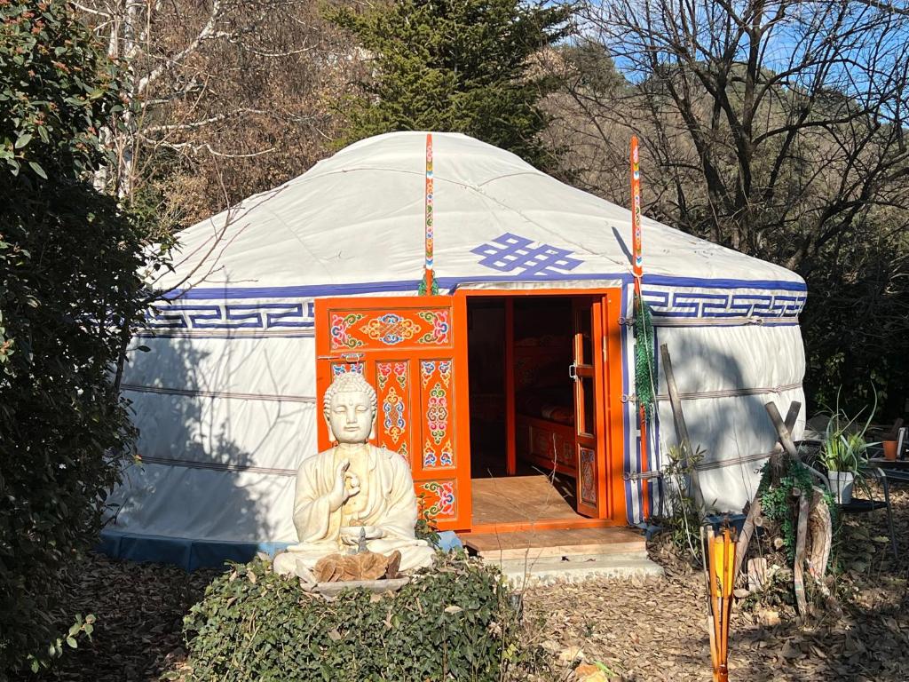 a buddha statue sitting in front of a yurt at Yourte piscine jacuzzi in Gréoux-les-Bains