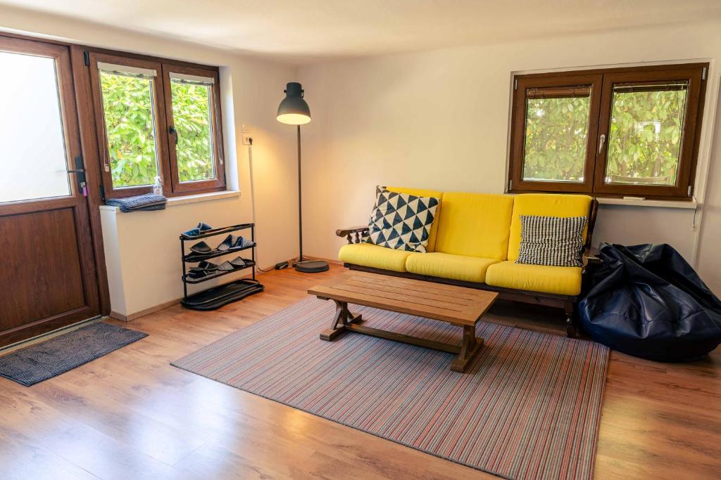 a living room with a yellow couch and a coffee table at Mediterranean Family design in Izola