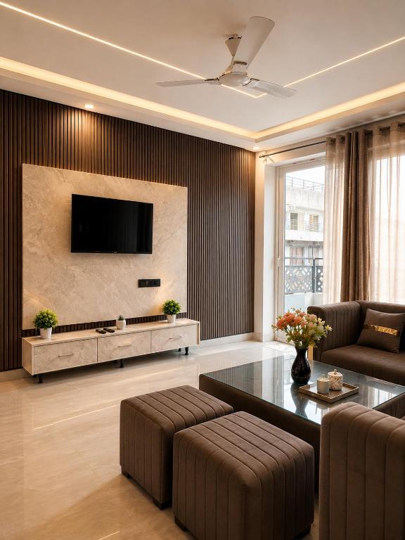 a living room with a couch and a tv on a wall at Elvora Stay's - Studio with Jacuzzi in Ghaziabad