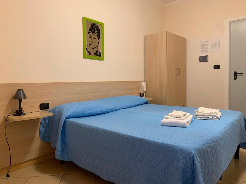a bedroom with a blue bed with towels on it at B&B Florida sul mare via faro 30 in Capo Rizzuto