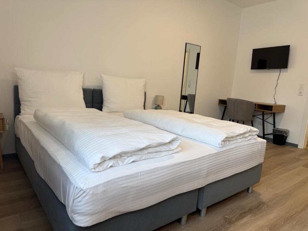 a bedroom with two beds with white sheets at Blue Stay Bremen in Bremen