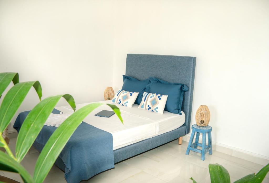 a bedroom with a blue and white bed with pillows at Charmant T1 - Vue Mer in Pointe-à-Pitre