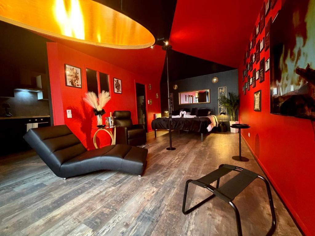 a living room with red walls and a couch at L'Atelier des Amoureux studio à 2 pas du château in Sedan