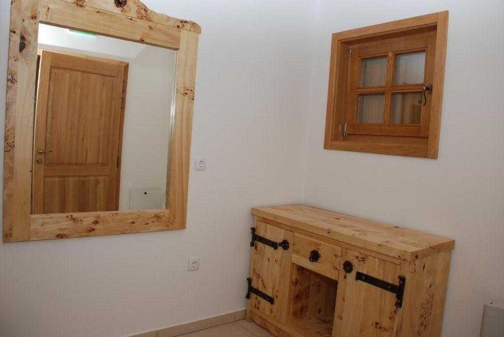 a bathroom with a mirror and a wooden cabinet at Balkis Resort in Bakinci