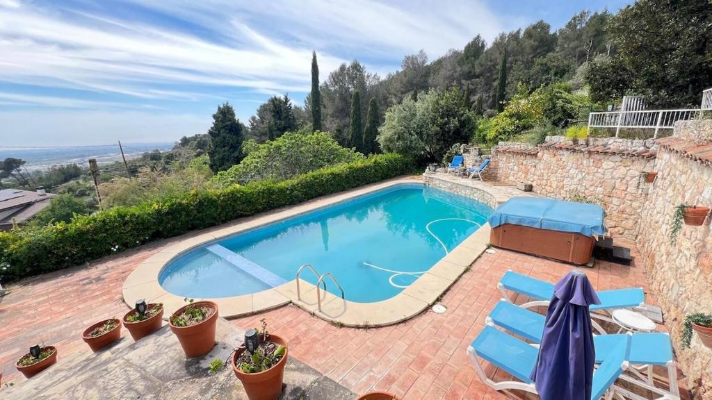 a swimming pool in a stone house with blue chairs at Drago Luxury Villa in Tarragona