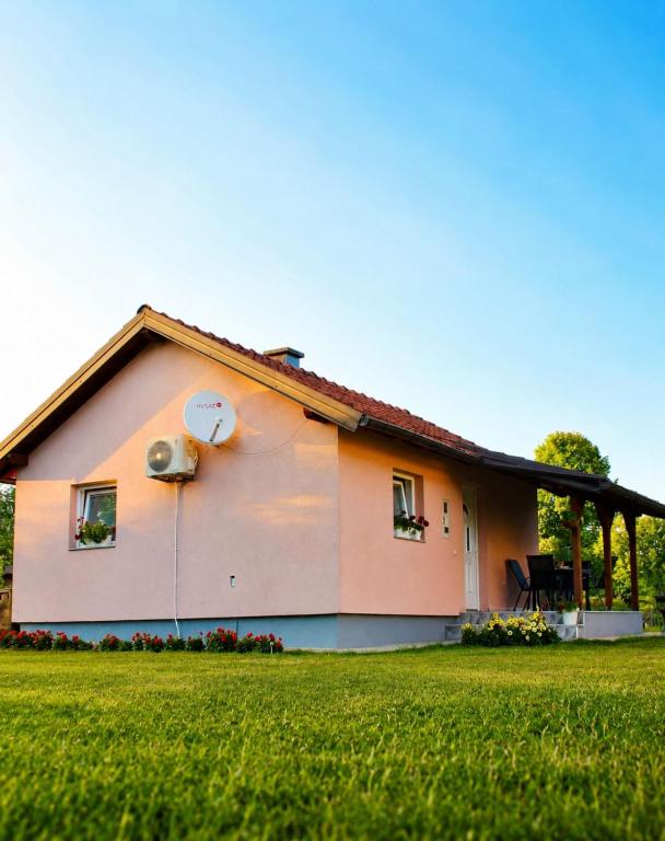 a house with a green lawn in front of it at Викендица Братунац in Bratunac