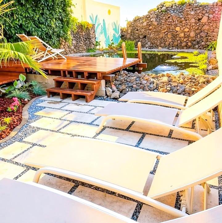 a patio with a table and chairs and a pond at Quinta Sao Roque in São Roque