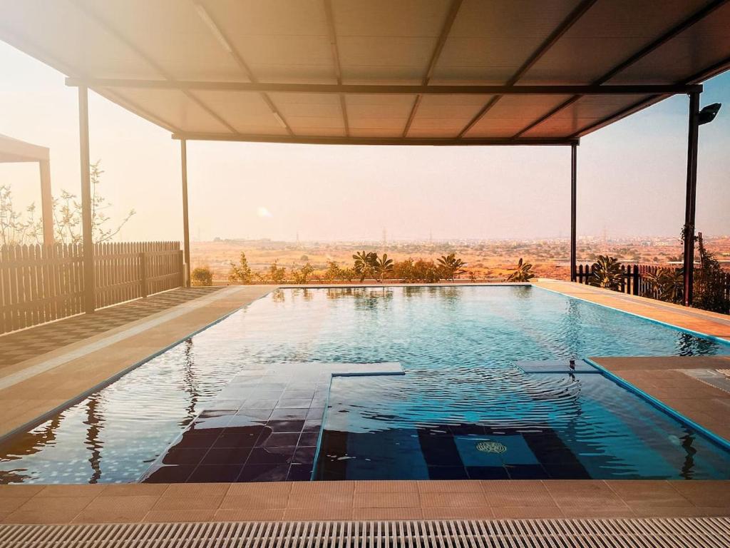 a swimming pool with a view of the desert at Desert Dune Farmhouse - By Seven Elements in Ras al Khaimah