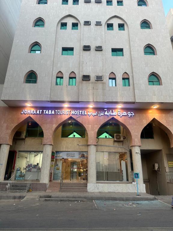 a building with a sign on the front of it at Johraat Taba Tourist Hostel in Medina