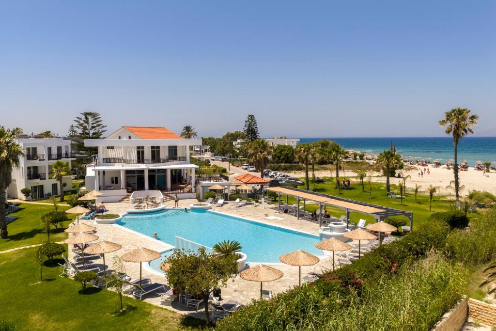 a resort with a swimming pool with umbrellas and the beach at Stella Maris in Kos
