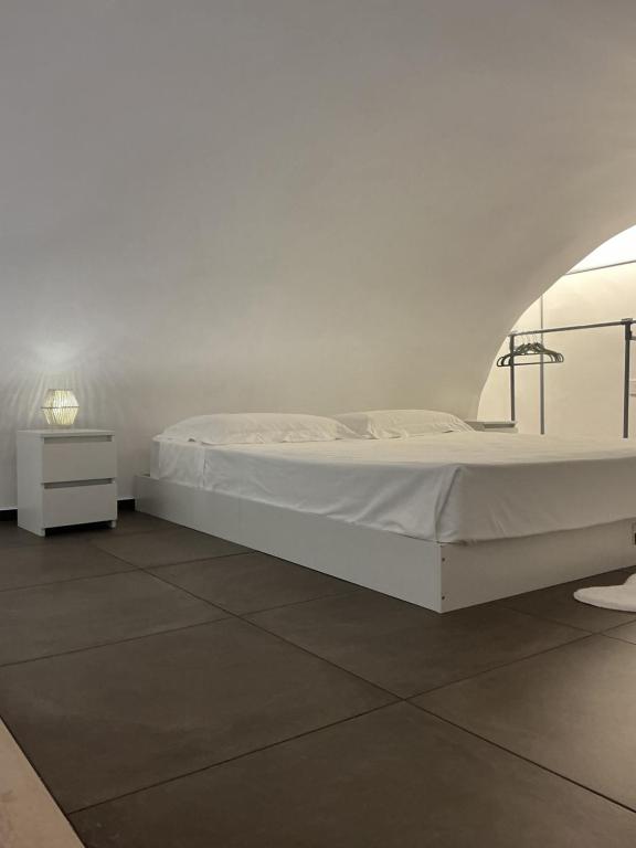 a white bed in a white room with a table at Moira Luxury Appartament in Bitonto