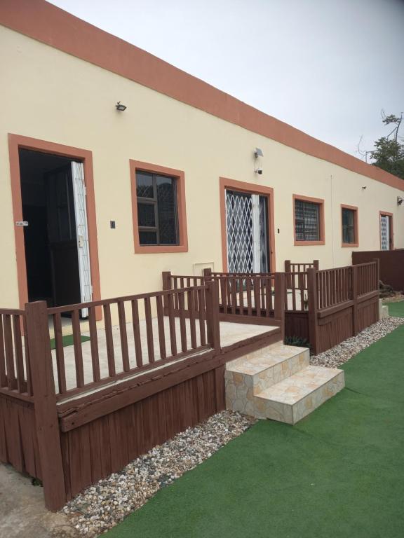 a house with a wooden fence and stairs in front of it at Ocean Wave Chalets Unit 1 in Hibberdene