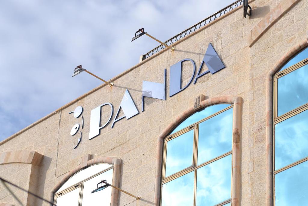 una señal en el lateral de un edificio con ventanas en Panda Hotel Apartments, en Amán