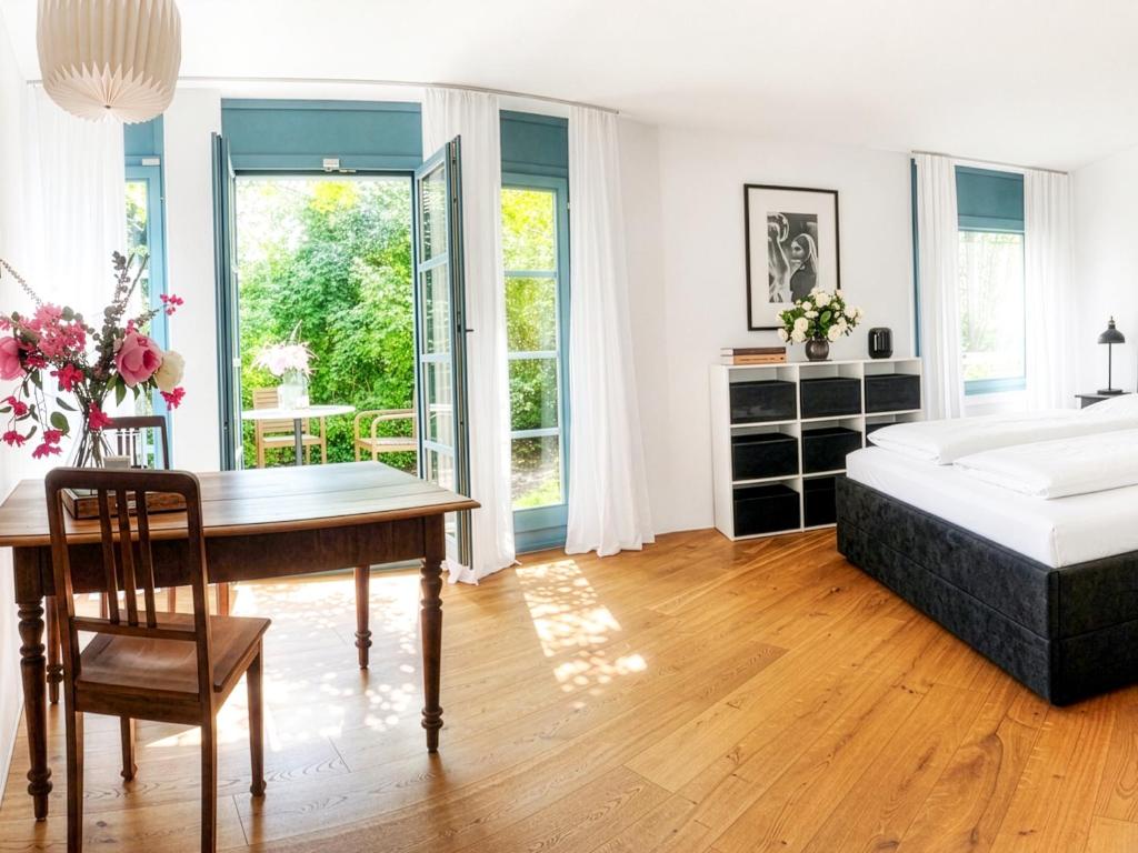 a bedroom with a bed and a desk and a table at Boutique Garden Studio in Kreuzlingen