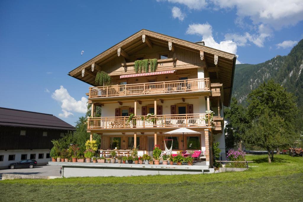 Casa de madera grande con balcón y flores en Landhaus Kumbichl, en Mayrhofen