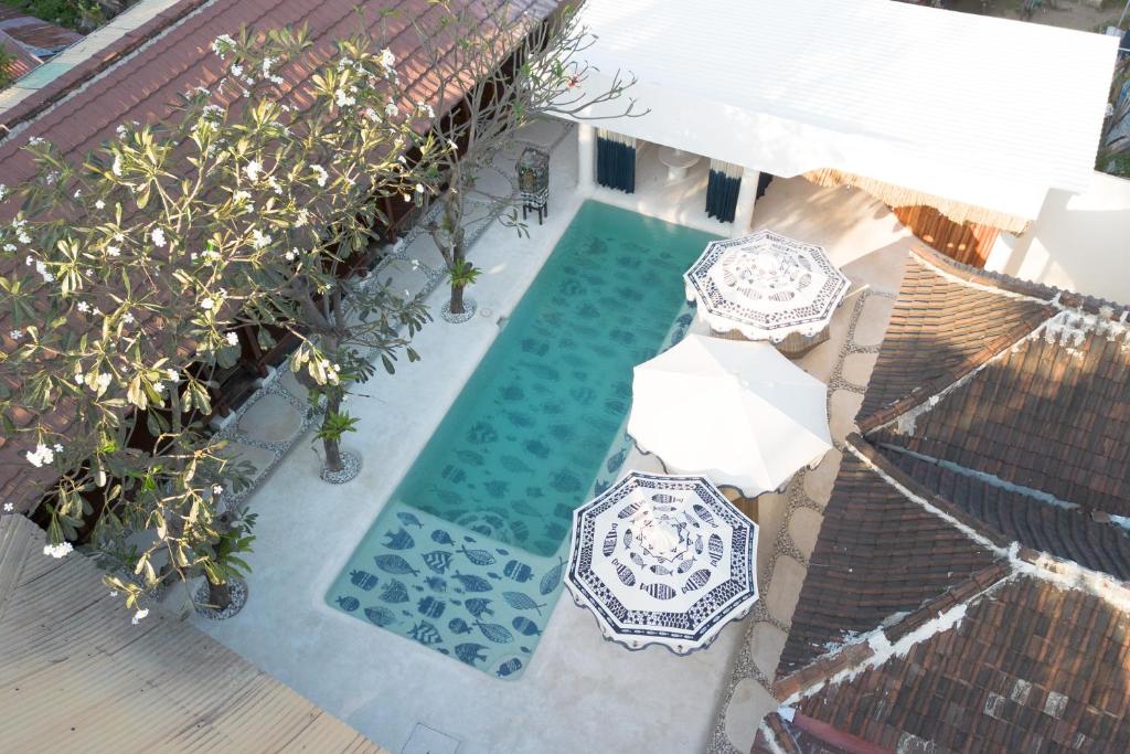 an overhead view of a swimming pool with an umbrella at Maresia in Gili Islands