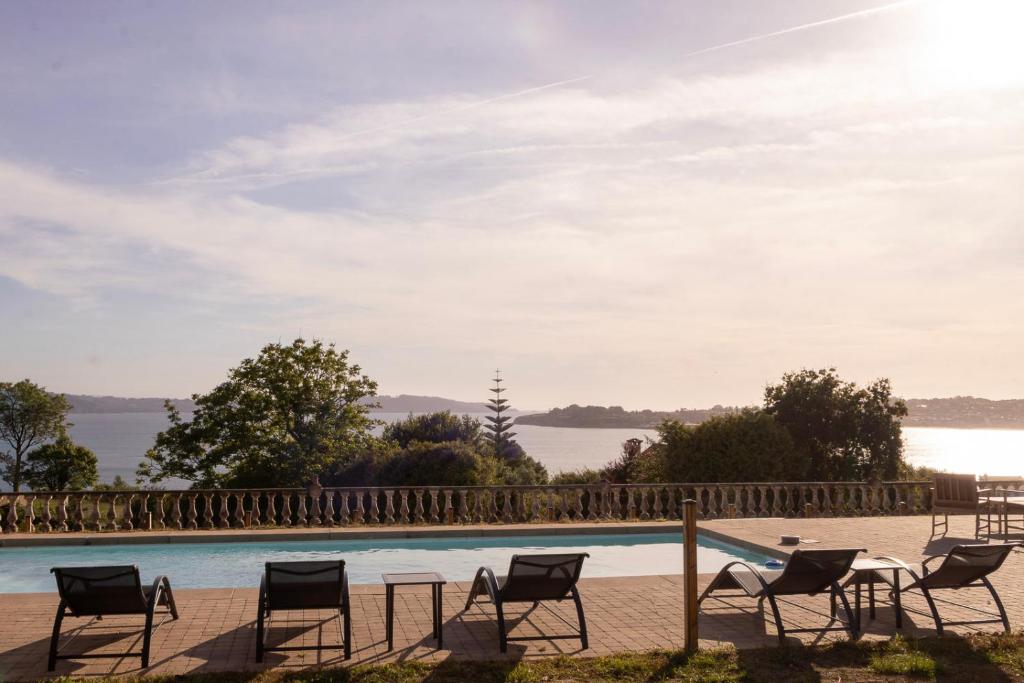 a group of chairs sitting next to a swimming pool at Raíces da Costa Ártabra in Islote Mouron