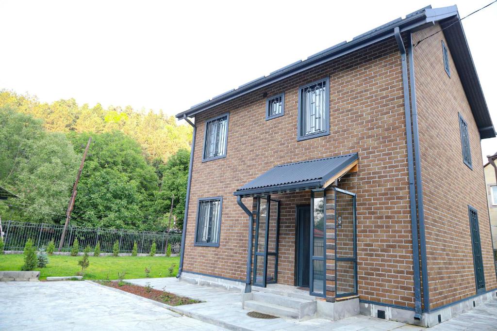 a red brick building with a black roof at EVORI Guesthouse in Dilijan