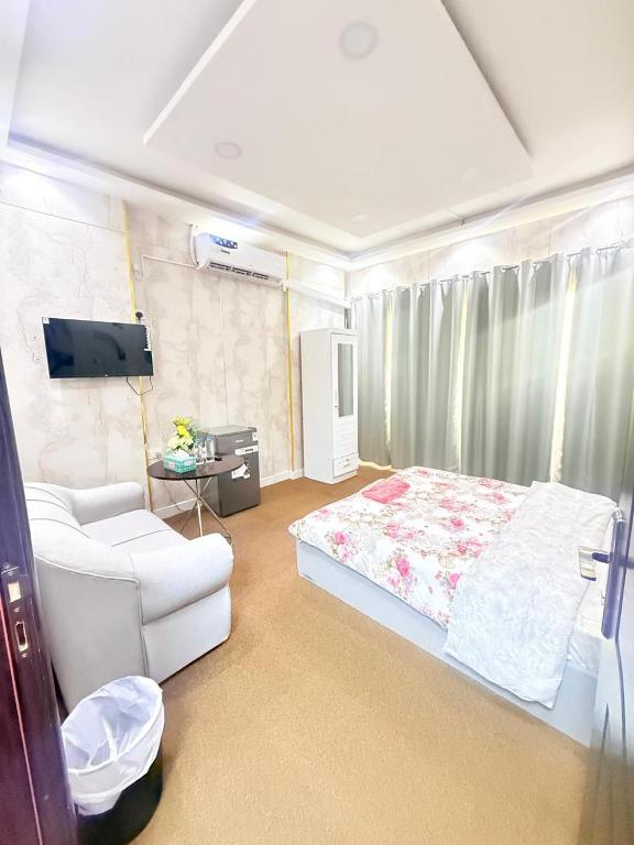 a bedroom with a bed and a couch and a tv at Holiday Abu Dhabi in Abu Dhabi