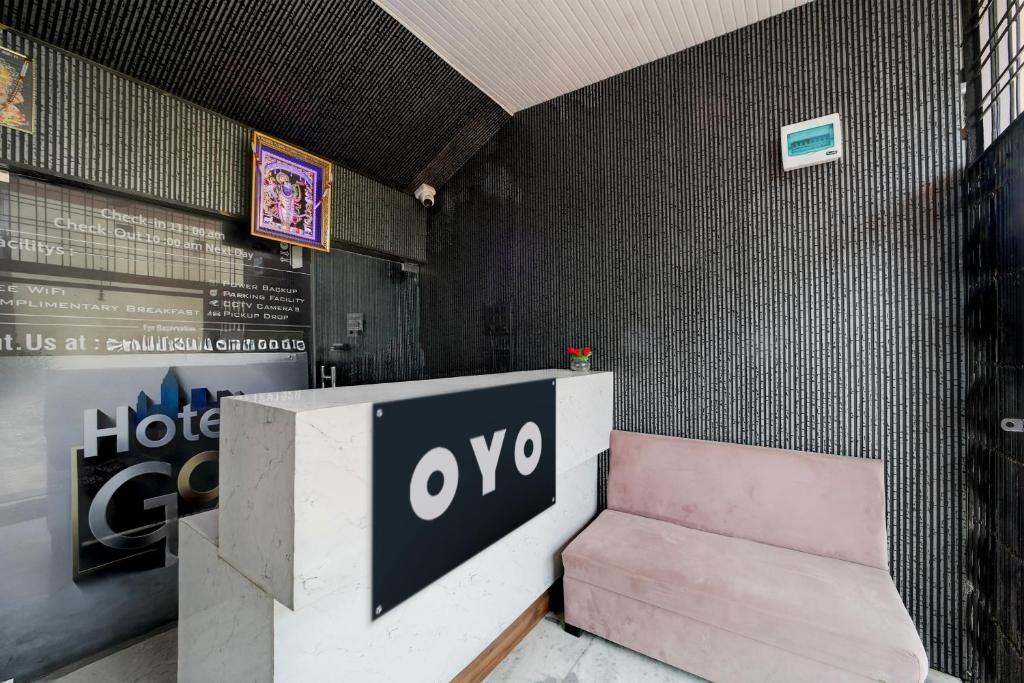 a pink bench next to a wall with a sign at Hotel O G9 in Indore
