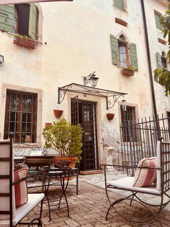 a patio with chairs and a table in front of a building at BaBi in Cison di Valmarino