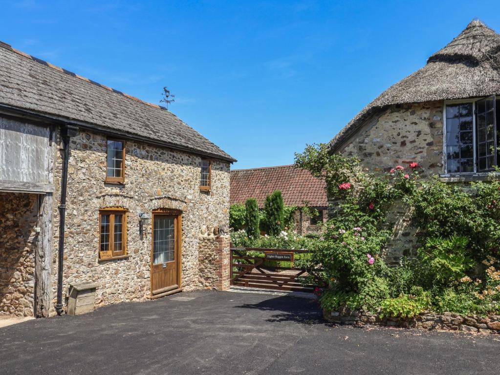 an old stone house with a gate and a yard at Rose Cottage in West Buckland