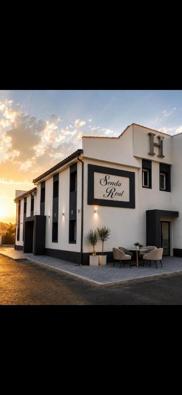 a building with a sign on the side of it at H SENDA ReAL in Alcuéscar