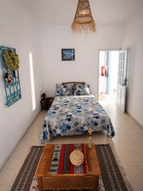 a bedroom with a bed and a coffee table at Dar Essadeg Bis in Tataouine