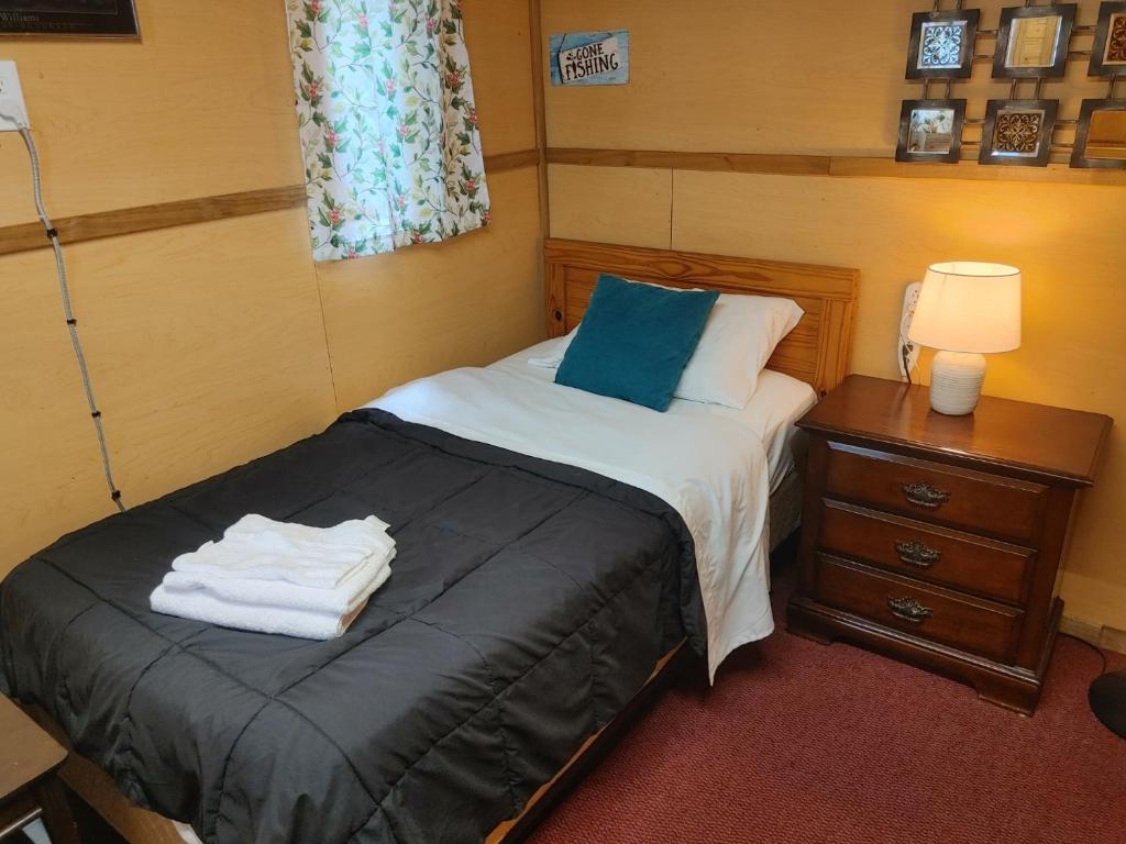 a bedroom with a bed with towels on it at Cozy Tree House in Saint John