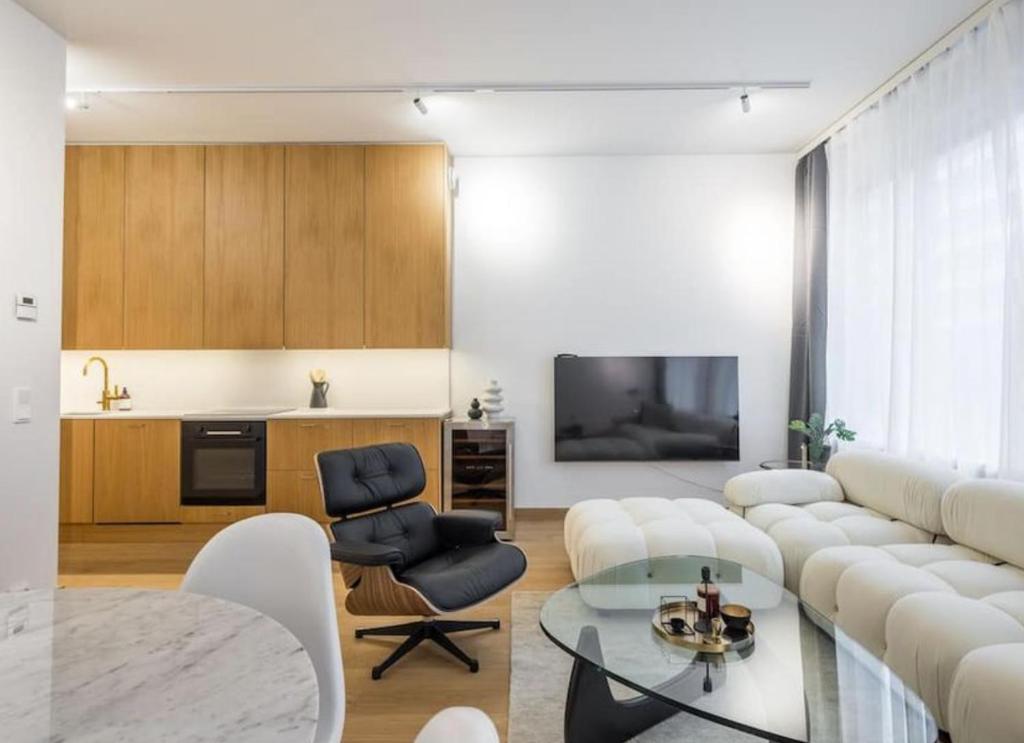 a living room with white furniture and a television at City Choice Apartment in Helsinki