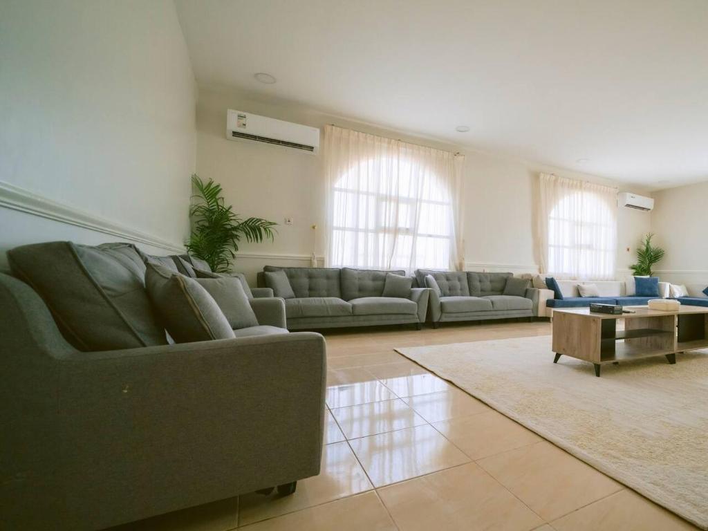a large living room with couches and a table at Hideout Farmhouse - By Seven Elements in Ras al Khaimah