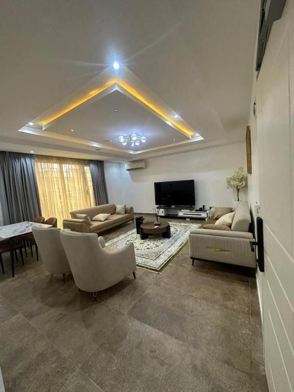 a living room with couches and a flat screen tv at Peev Apartements in Abuja