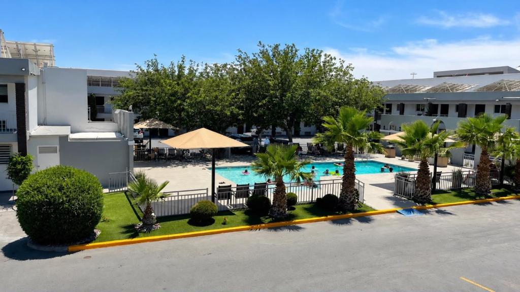 an overhead view of a resort pool with palm trees at Hotel Villa del Sol in Ciudad Juárez
