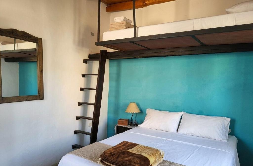 a bedroom with two bunk beds and a mirror at Acogedora cabaña Hospedaje Mérida in Mérida